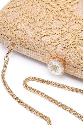 Gold textured clutch bag with a chain strap on a white background