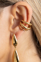 Close-up of a person wearing gold earrings.