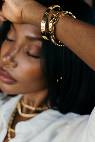 Woman wearing gold jewelry with a blurred background