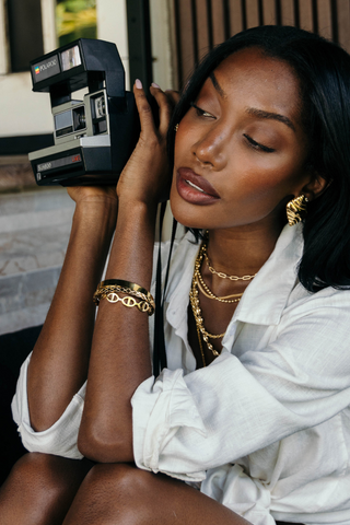 Woman holding a vintage Polaroid camera with a blurred background