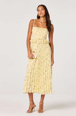 Woman wearing a yellow floral dress on a white background
