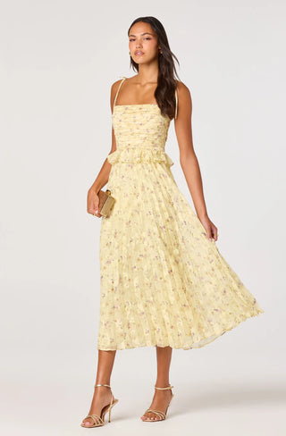 Woman wearing a yellow floral dress on a white background