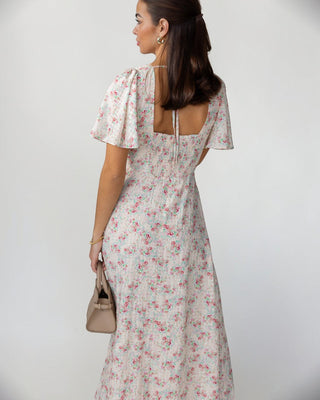 Woman wearing a floral dress with a plain background