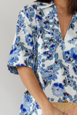 Front patch pocket detail on women's Cala blue floral cotton denim mini dress in relaxed oversized fit