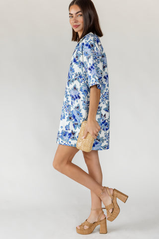 Side view of women's Cala floral denim mini dress showing relaxed oversized fit and lightweight 100% cotton fabrication in blue floral on white
