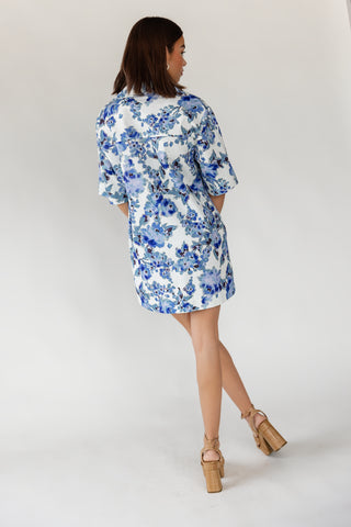 Back view of women's Cala oversized floral cotton denim mini dress in sky to navy blue floral print on crisp white base