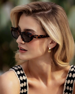 Woman wearing sunglasses with a blurred natural background