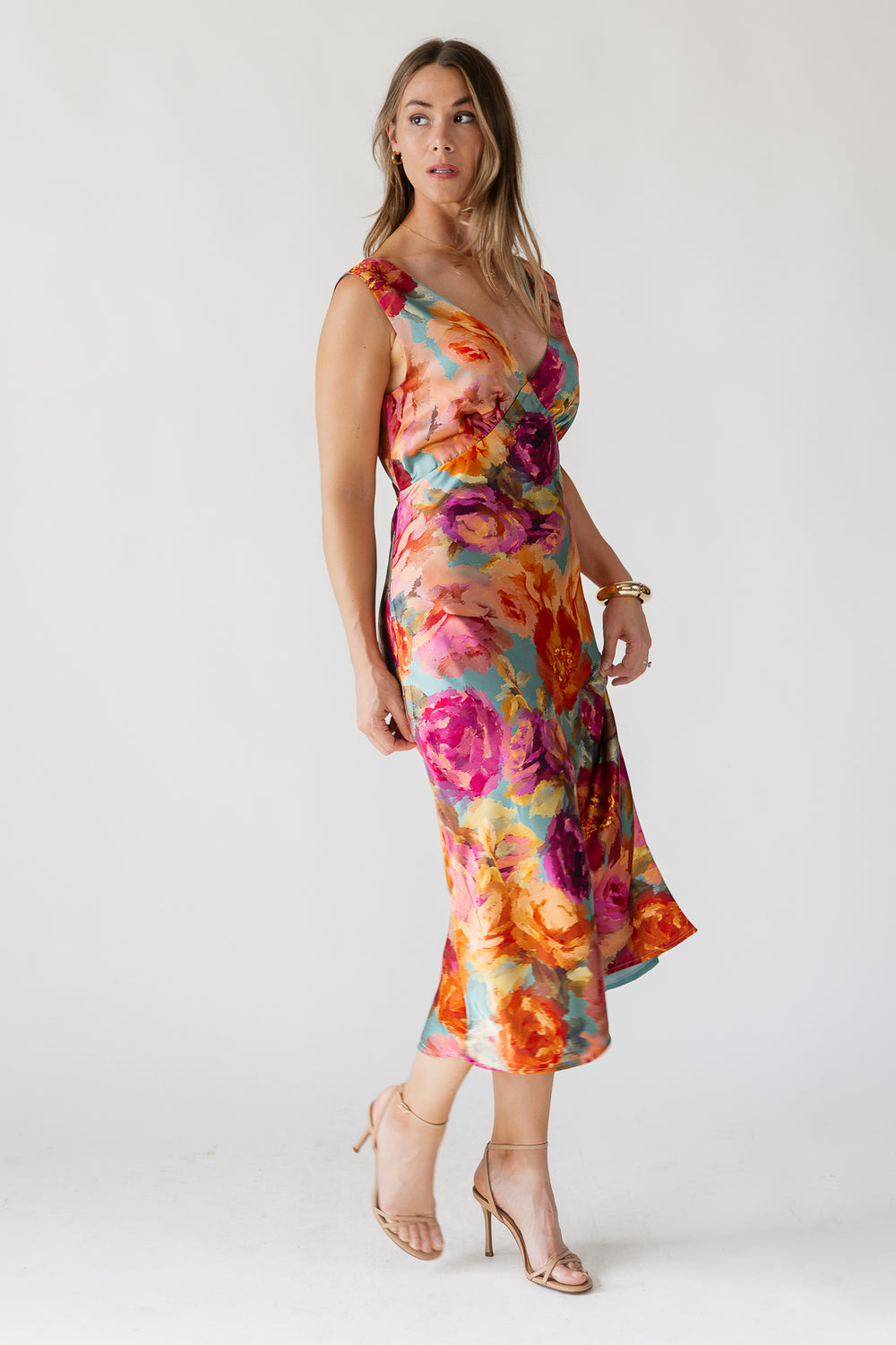 Woman wearing a colorful floral dress on a white background