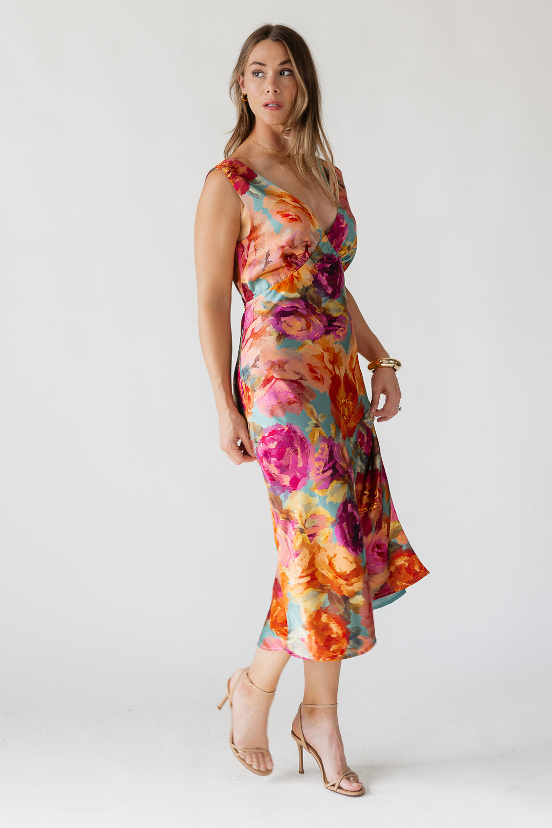 Woman wearing a colorful floral dress on a white background