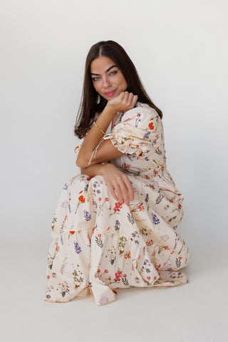 Woman wearing a floral dress sitting on a white background