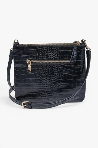Back view of black croc texture crossbody bag with hidden exterior zip pocket and adjustable strap