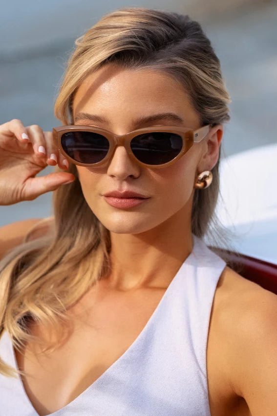Woman wearing sunglasses by a body of water