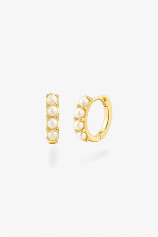 Women's gold pearl huggie earrings with freshwater pearls and polished finish