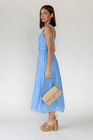 Side view of women's Positano French blue cotton eyelet midi dress showing belted waist, side pocket and full midi length