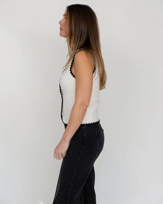 JO+CO cream knit sleeveless vest with black scalloped trim and gold buttons. Fitted silhouette.