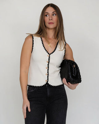 JO+CO cream knit sleeveless vest with black scalloped trim and gold buttons. V-neck, fitted silhouette.